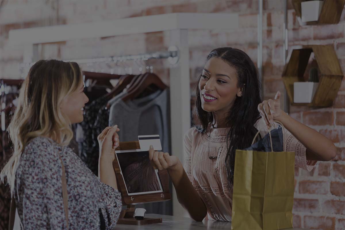 Cashier Helping Customer At Checkout Counter Of Store