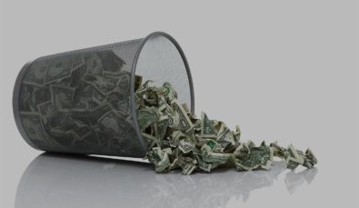 Garbage Can Full Of Money Tipped On Side Spilling Money