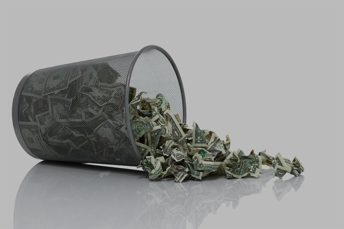 Garbage Can Full Of Money Tipped On Side Spilling Money