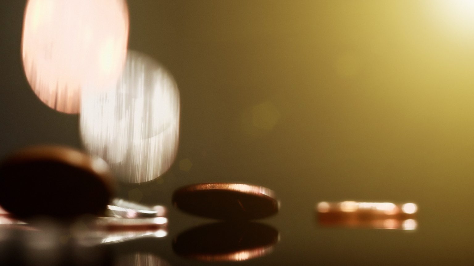 Copper And Silver Coins Falling Onto Shiny Surface