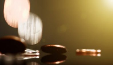 Copper And Silver Coins Falling Onto Shiny Surface