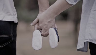 hands linked together with baby shoes | wealth management strategies by MGI