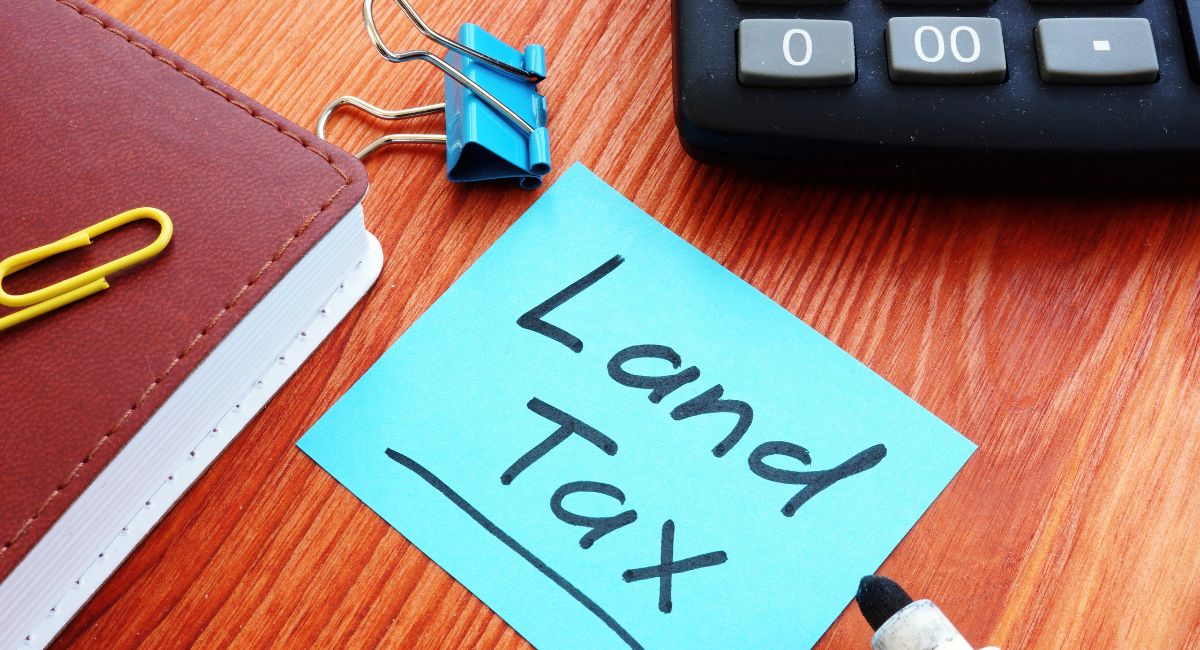 Land Tax written on a post it note on a desk signalling queensland land tax changes