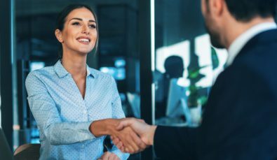 businesswoman shaking hands with a man after applying for the business basics grant