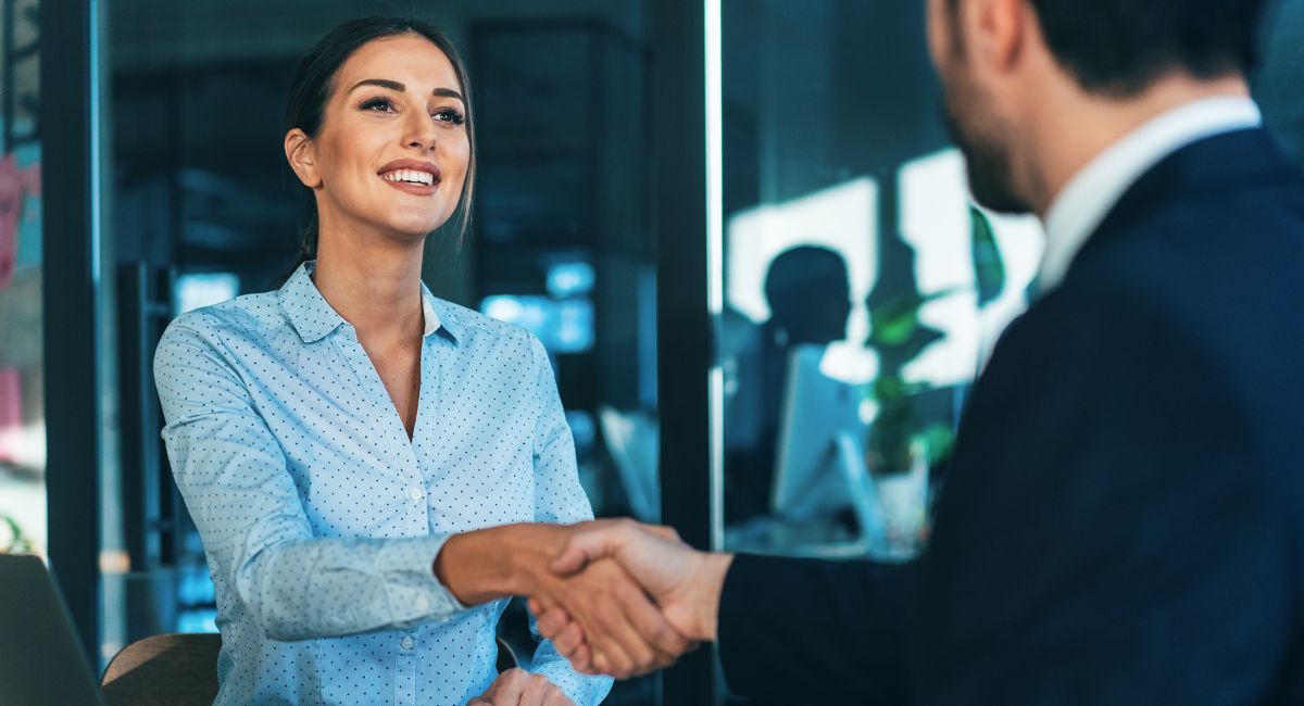 businesswoman shaking hands with a man after applying for the business basics grant