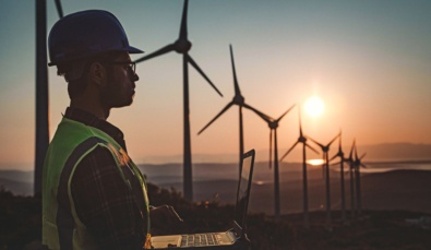 man with laptop surveying wind farm to develop new technology for the renewable Energy Grant