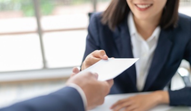 pay slip being handed to a female employee under Modern Award Pay Rates changes