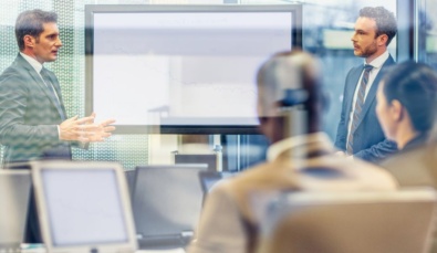 a virtual cfo in a boardroom in discussion with 3 business executives