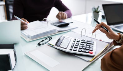 Close Up,of,two,businesspeople,calculating,financial,statement,at,desk