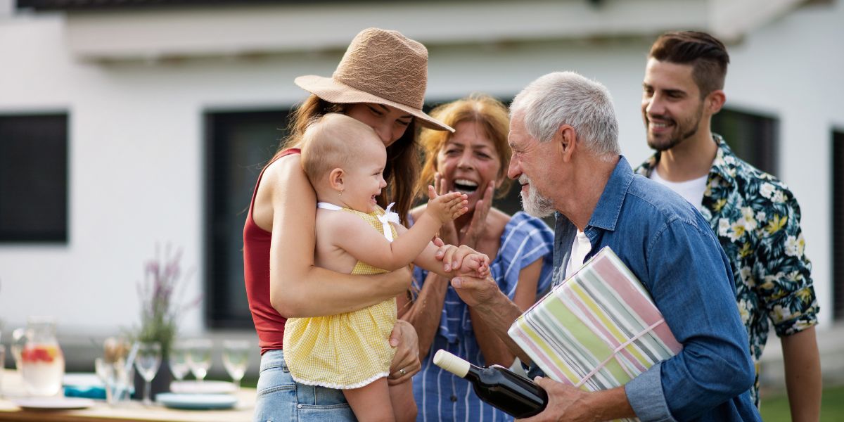 three generations of a family including grandparents, parents and a baby at a outdoor family gathering used on a blog about estate planning